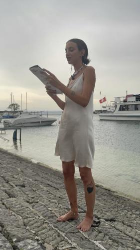 Lecture d'Hélène au Cabanon du Naturiste (port de Neuchâtel) pour le vernissage du numéro Paradis perdu, août 2023.